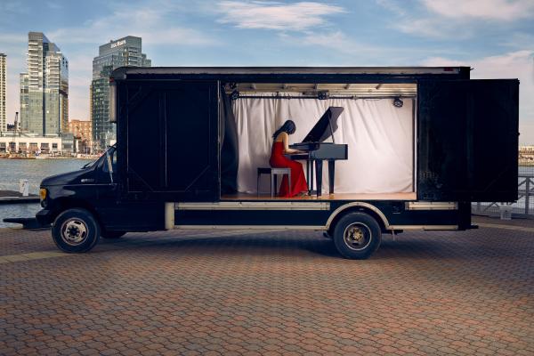 musicians performing on a piano by a river